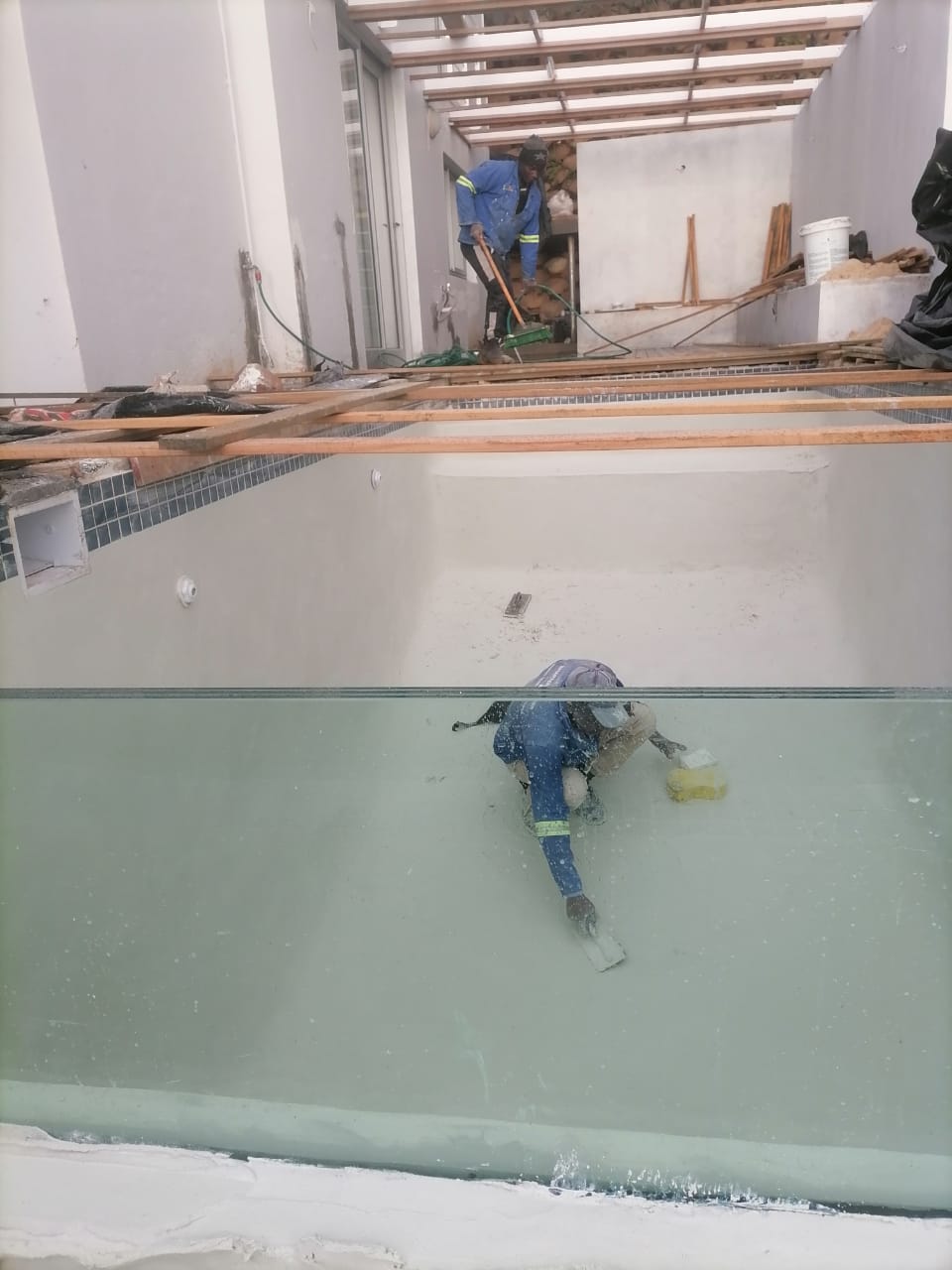 A technician working in an indoor pool as it is filled following a renovation